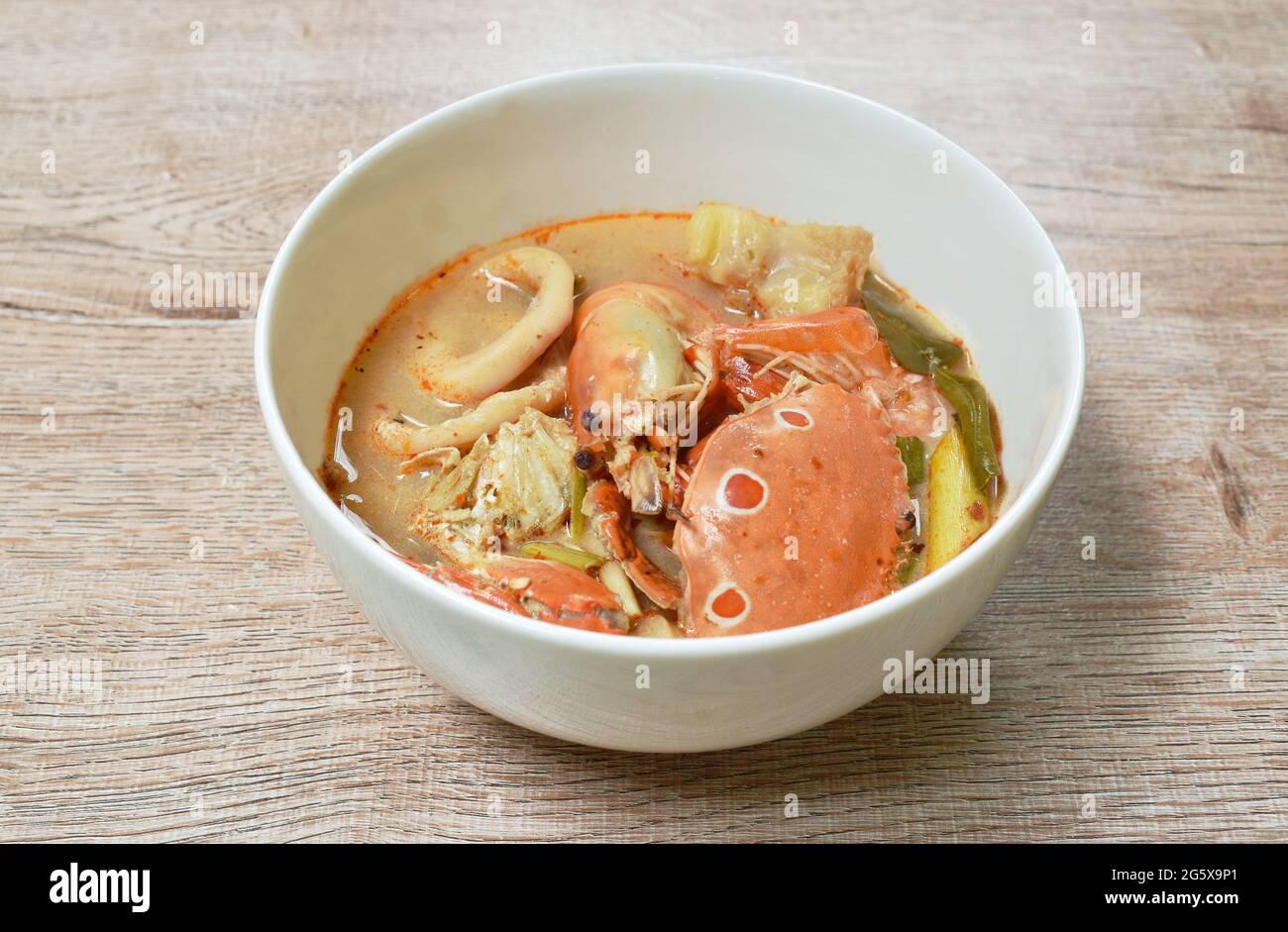 Gekochte Blumenkrabben und Garnelen verbinden Tintenfisch mit Dolly-Fisch in einer thailändischen, würzigen Suppe oder Fisch mit tom Yum auf der Schüssel Stockfoto