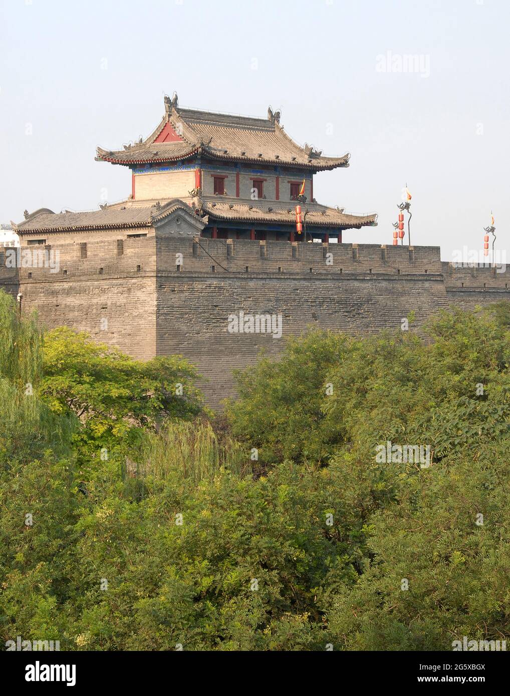 Stadtmauer, Xian, Provinz Shaanxi, China. Die Stadtmauer von Xian ist eine der am besten erhaltenen in China. Wachturm an der Stadtmauer von Xian mit Blick auf Bäume. Stockfoto