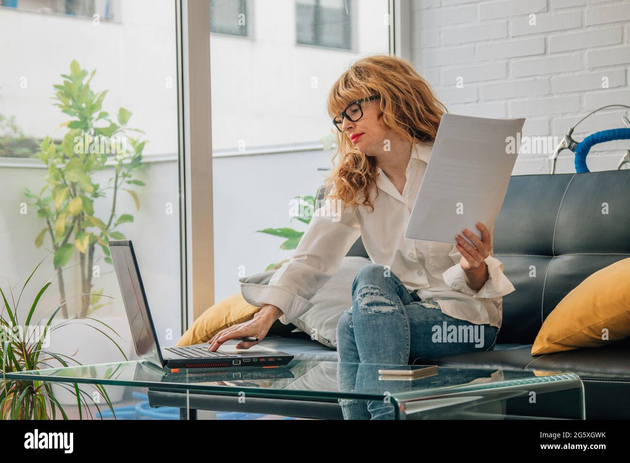 Geschäftsfrau, die mit Dokumenten und Laptop arbeitet Stockfoto