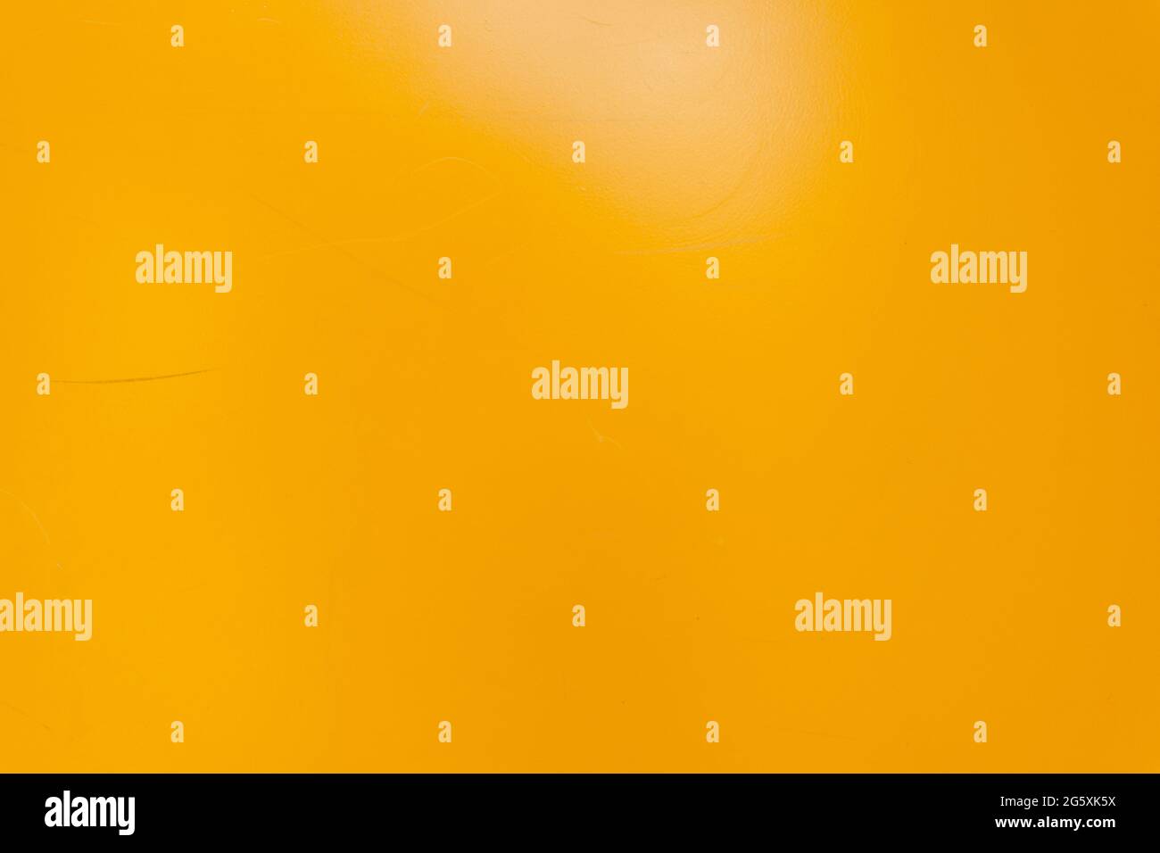 Strukturierte Wand in gelber Metallic-Optik. Hintergrund mit kleinen Kratzern. Wand des Hauses ist gelb gestrichen Stockfoto