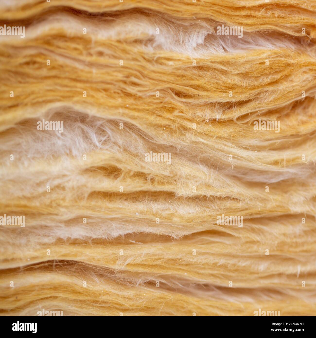Gelbe und weiße Fasern der isolierenden Wolle. Stockfoto