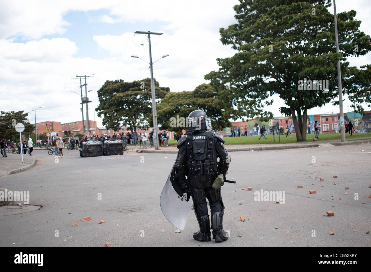 Die kolumbianischen Bereitschaftspolizisten (ESMAD) benutzen Polizeiknüppel, Tränengaskanister und Blitzbang-Grendanden, Stuntgranaten, während die Einwohner von Fontanar - Suba in Bogota, Kolumbien, gegen die kolumbianische Bereitschaftspolizei protestierten und zusammenbrachen (Escuadron Movil Antidisturbios ESMAD) Gegen den Besuch des kolumbianischen Präsidenten Ivan Duque Marquez in einem Park, in dem das U-Bahnnetz von Bogota errichtet wird, während der zwei Monate lang regierungsfeindliche Proteste gegen den Präsidenten Ivan Duque Marquez, Ungleichheiten und Polizeiunruhen während der Proteste am 29. Juni 2021. Stockfoto