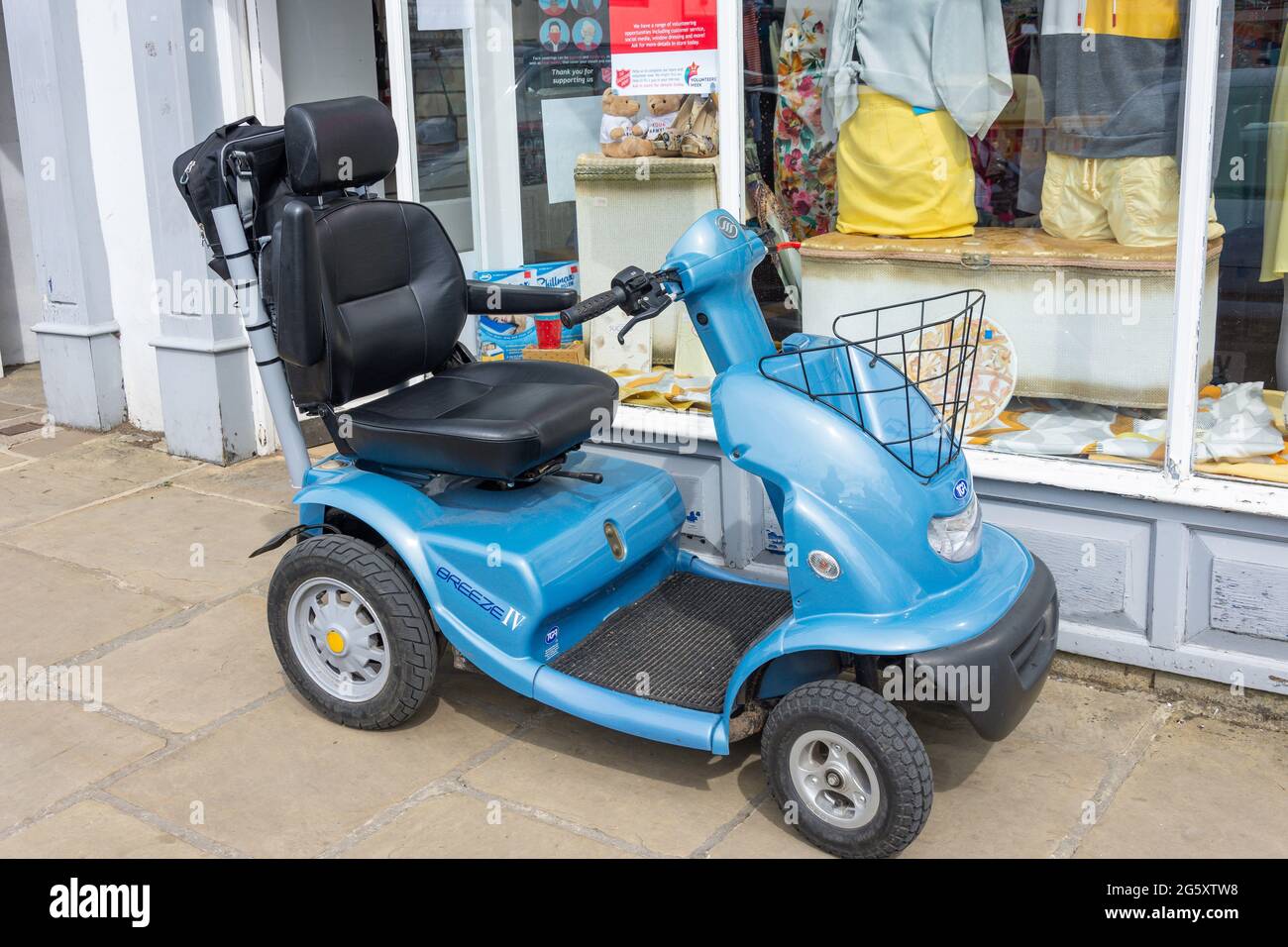 TGA Breeze IV Mobilitäts-Scooter vor dem Wohltätigkeitsgeschäft, Market Place, Thirsk, North Yorkshire, England, Vereinigtes Königreich Stockfoto