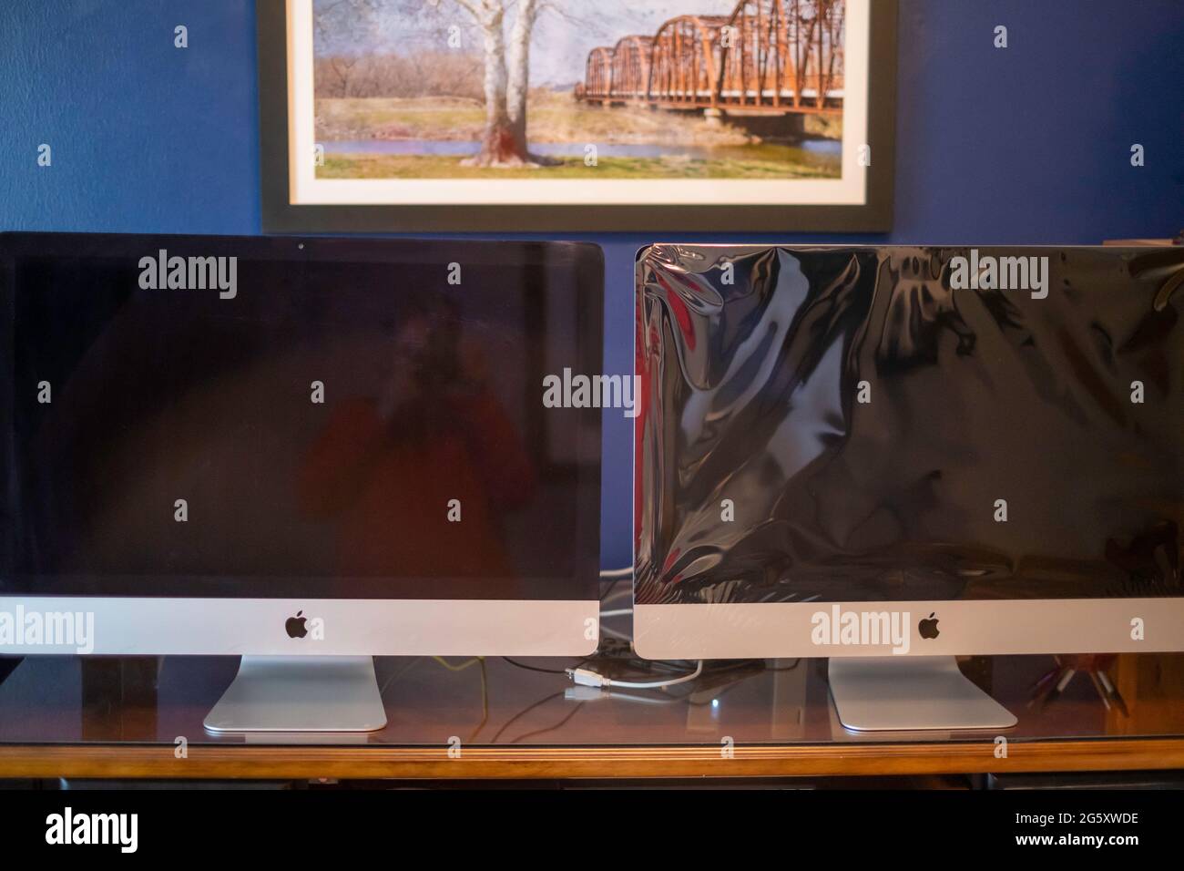 2013 iMac sitzt neben einem 2020 neuen iMac auf einem Schreibtisch im Heimbüro. Stockfoto