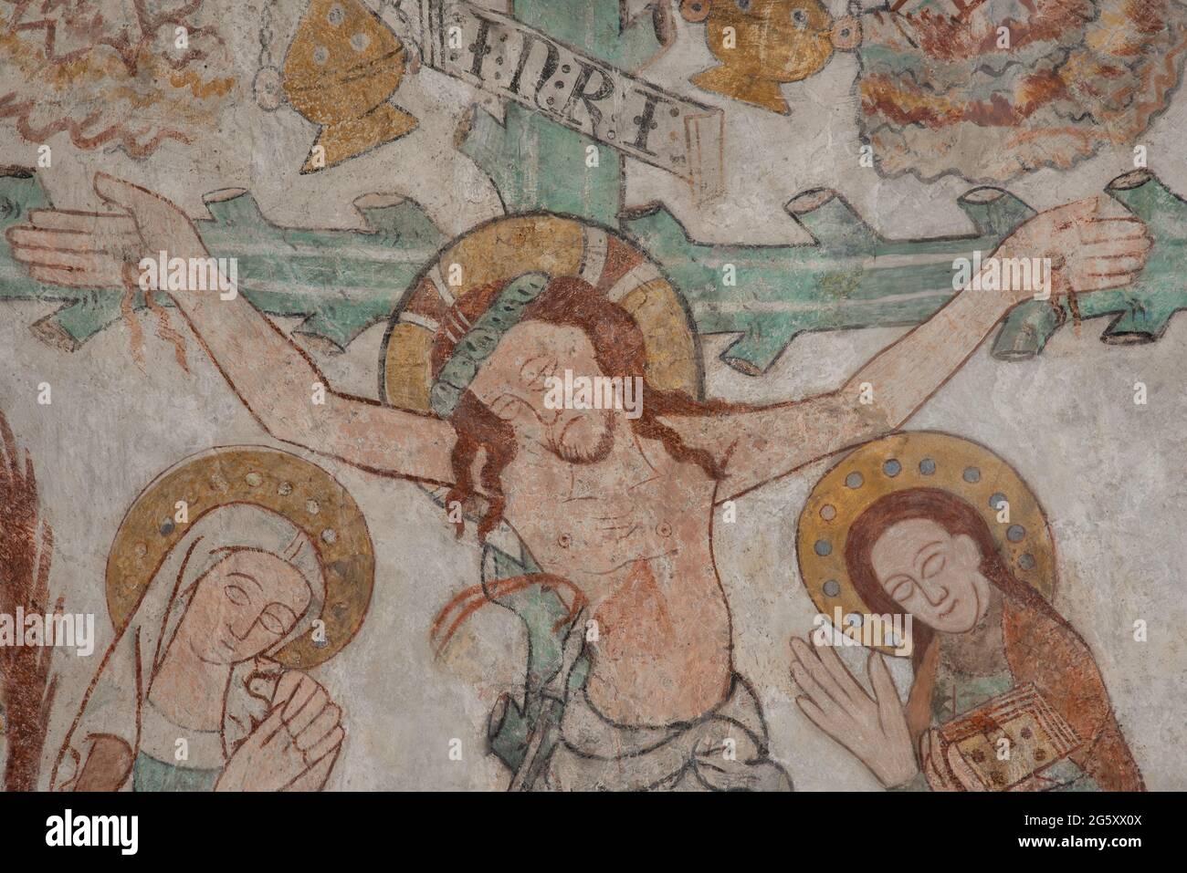 Christus wird an ein grünes Kreuz genagelt. Maria und Johannes trauern, ein altes Wandgemälde in der Skibby Kirche, Dänemark, 28. Juni 2021 Stockfoto