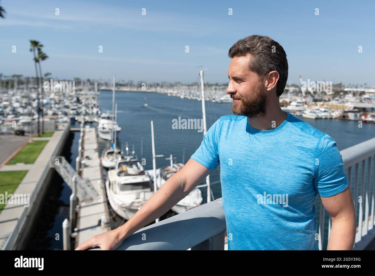 Schöner Mann Urlauber stehen an Brücke Geländer über Fluss Sommer im Freien, Urlaub Stockfoto
