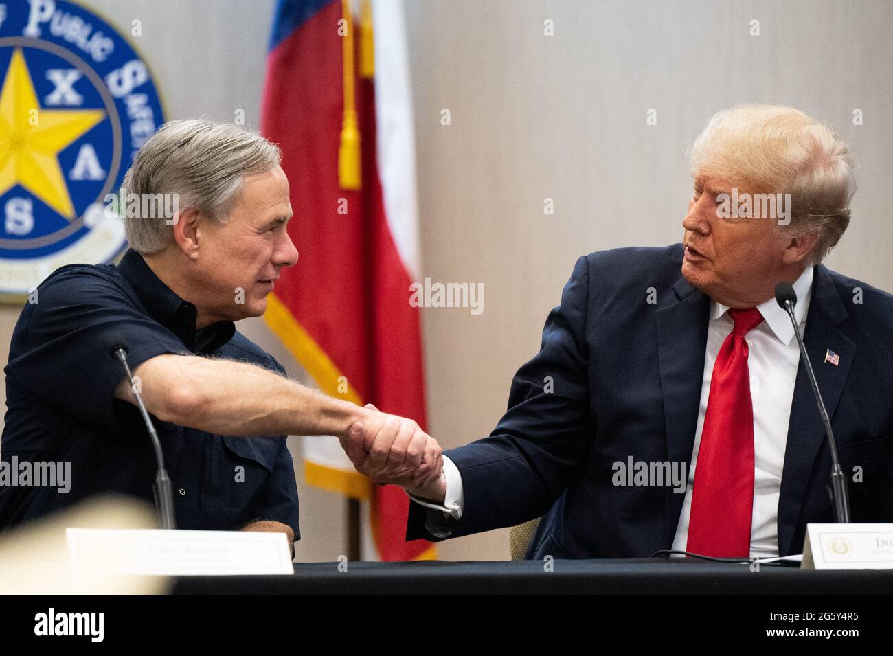 Weslaco, Texas, USA. 30. Juni 2021. WESLACO, TEXAS - JUNI 30: Texas Gov. GREG ABBOTT und der ehemalige Präsident DONALD TRUMP schütteln sich die Hände während einer Sicherheitsbesprechung am 30. Juni 2021 in Weslaco, Texas. Gov. Abbott hat zugesagt, eine staatlich finanzierte Grenzmauer zwischen Texas und Mexiko zu errichten, da ein Anstieg von hauptsächlich mittelamerikanischen Einwanderern, die in die Vereinigten Staaten einwandern, die US-Einwanderungsbehörden herausgefordert hat. Bisher haben Agenten der US-Grenzpolizei im Jahr 2021 mehr als 900,000 Einwanderer festgenommen, die an der Südgrenze in die Vereinigten Staaten einwanderten. POOL/Brandon Bell (Bild: © Stockfoto