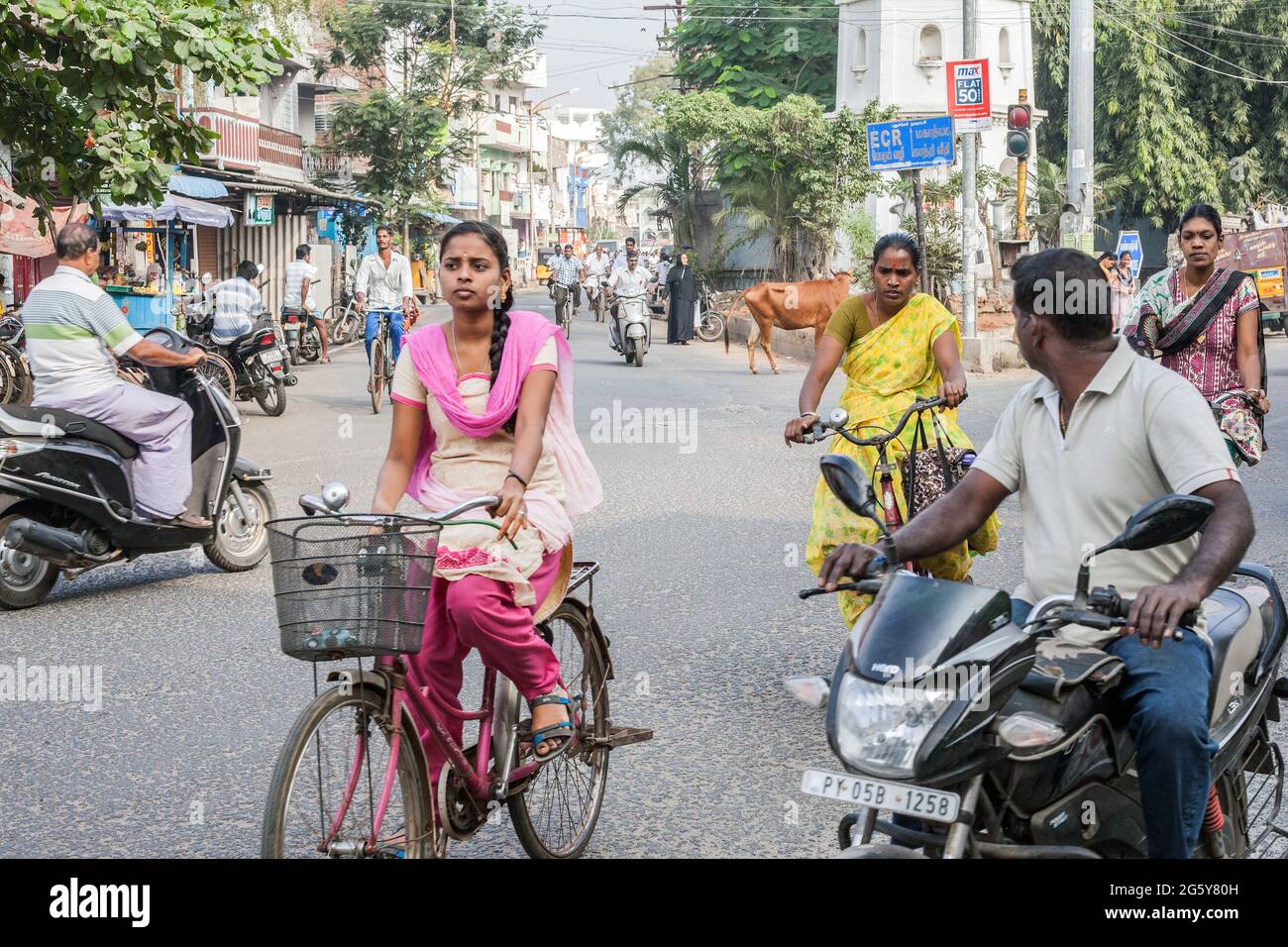 Indische Frauen fahren Fahrräder und Männer fahren Motorräder während der Hauptverkehrszeit ohne Sturzhelme im Verkehr, Puducherry (Pondicherry), Tamil Nadu, Indien Stockfoto