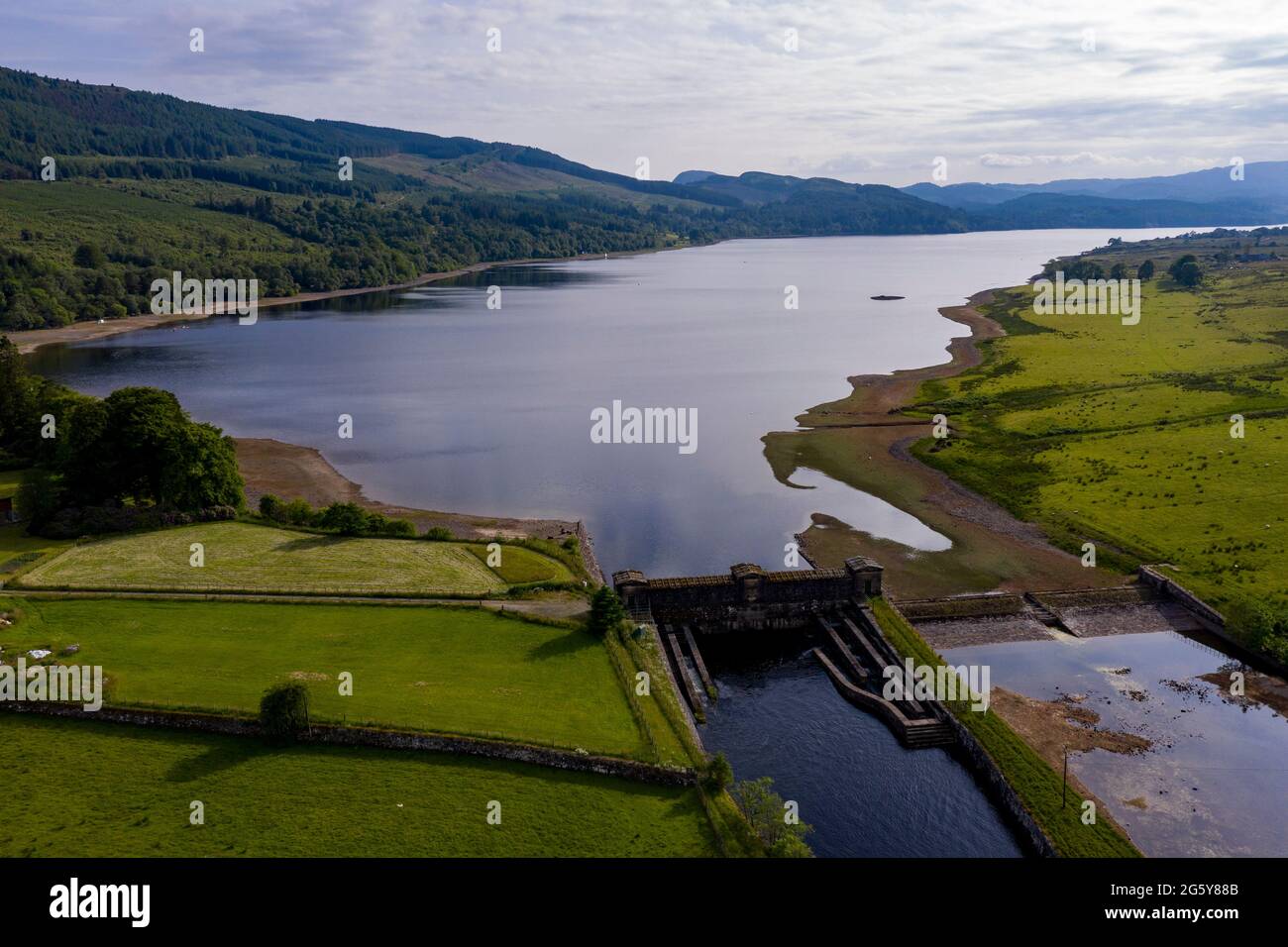 Loch Venachar, Loch. Lomonnd und Trossachs National Park, Schottland, Großbritannien. 30. Juni 2021. IM BILD: Eine Weitwinkelansicht des Kies- und Steinstrandes am Loch Venachar, der normalerweise unter ein paar Fuß Wasser liegt, ist aufgrund der schwindenden Wasserversorgung, die aufgebraucht ist, freigelegt. An diesem Teil des loch sollte es keinen Strand geben, aber man kann sehen, wie die Leute diesen Make Shift-Strand benutzen, um die Abendsonne zu genießen. Quelle: Colin Fisher/Alamy Live News Stockfoto