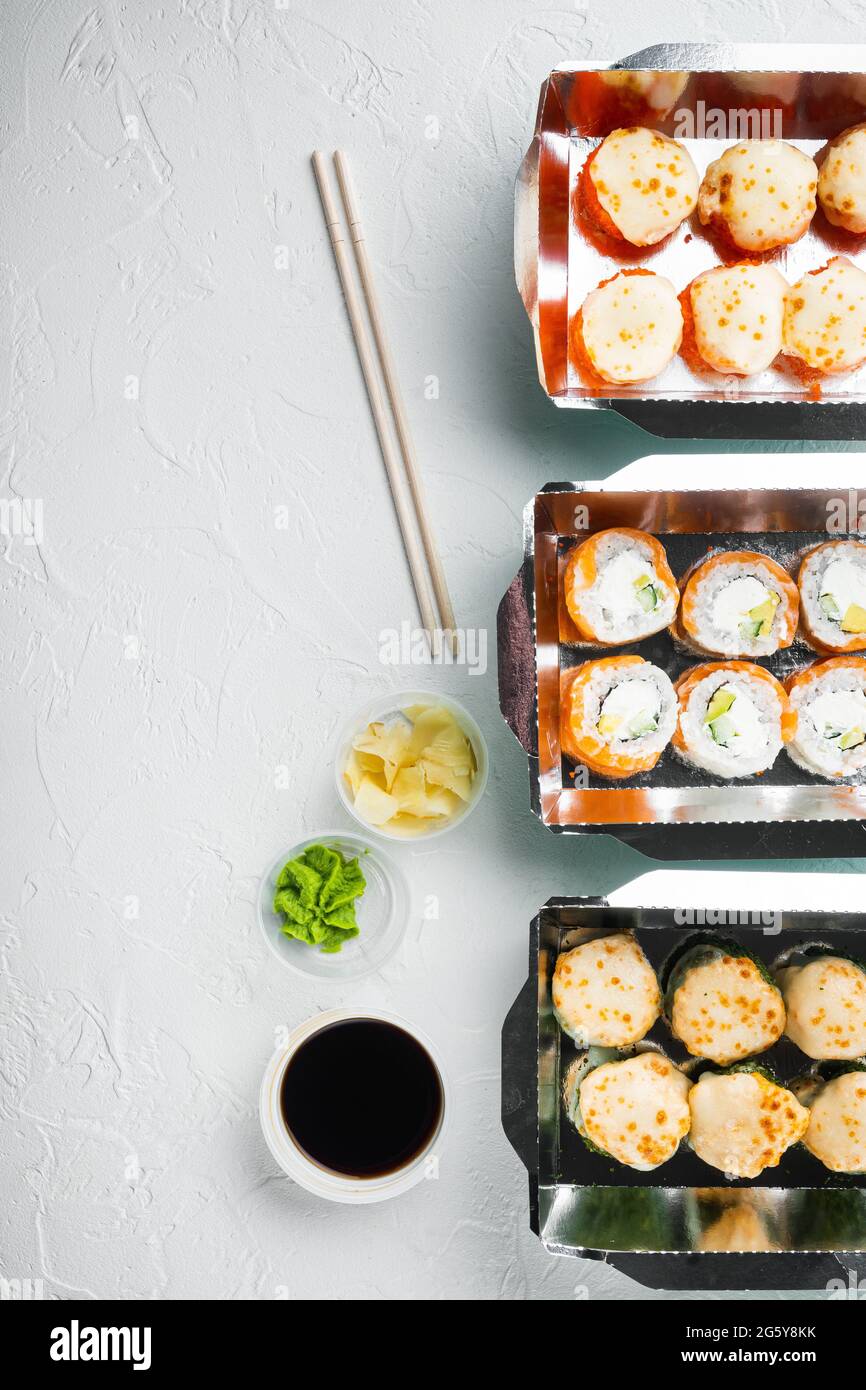 Set von Sushi-Rollen in Lieferung Food-Box-Set, auf weißem Stein Hintergrund, Draufsicht flach legen, mit Copyspace und Platz für Text Stockfoto