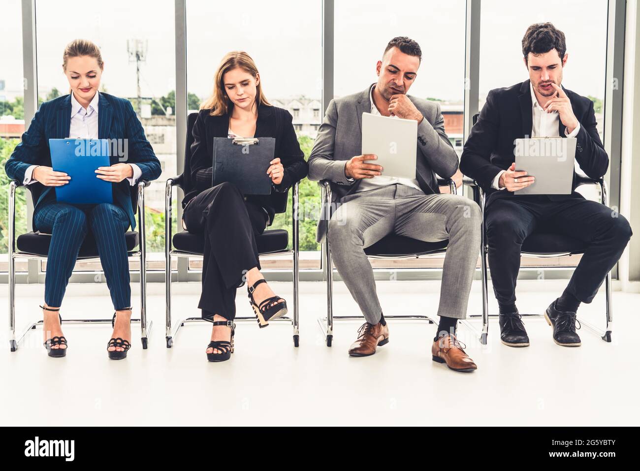 Geschäftsfrauen und Geschäftsleute halten Lebenslauf Ordner beim Warten auf Stühlen im Büro für Vorstellungsgespräch. Unternehmensgeschäft und Personalwesen Stockfoto