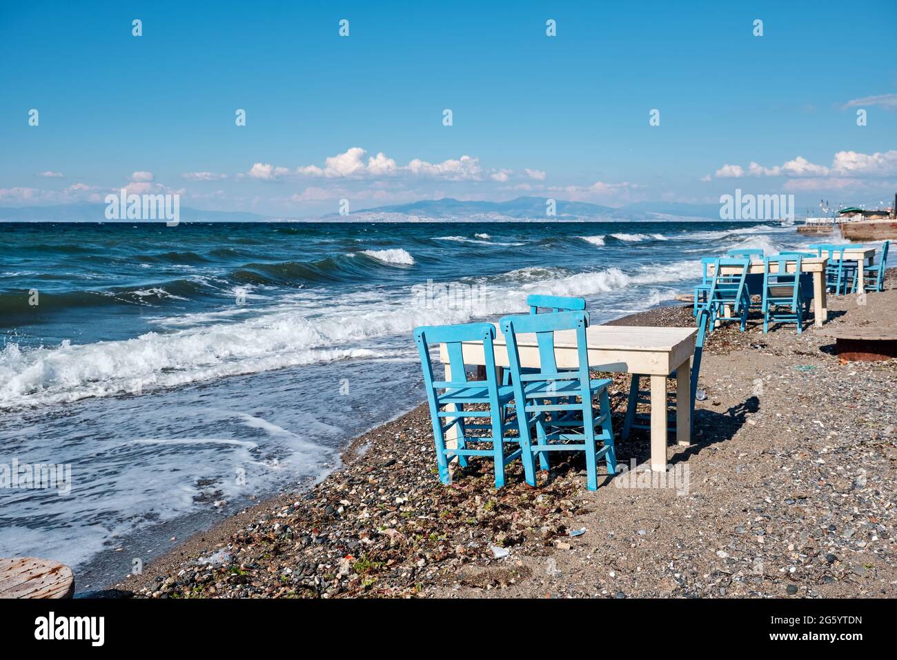 Blaue Holzstühle und Tische eines Restaurants oder Cafés am Meer Stockfoto