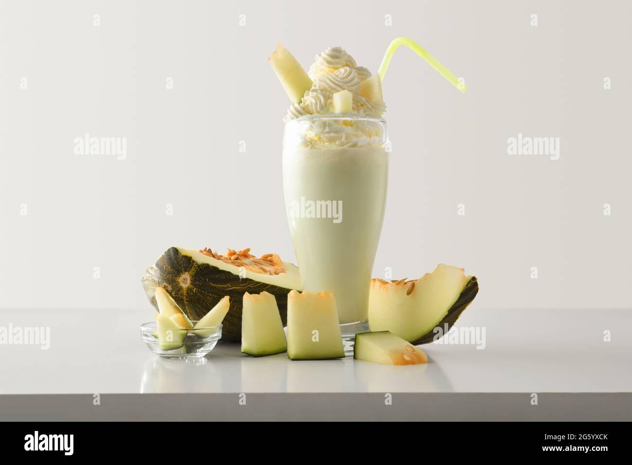 Melone Milchshake mit Creme verziert mit Obst um auf weißem Tisch und Licht isoliert Hintergrund. Vorderansicht. Stockfoto