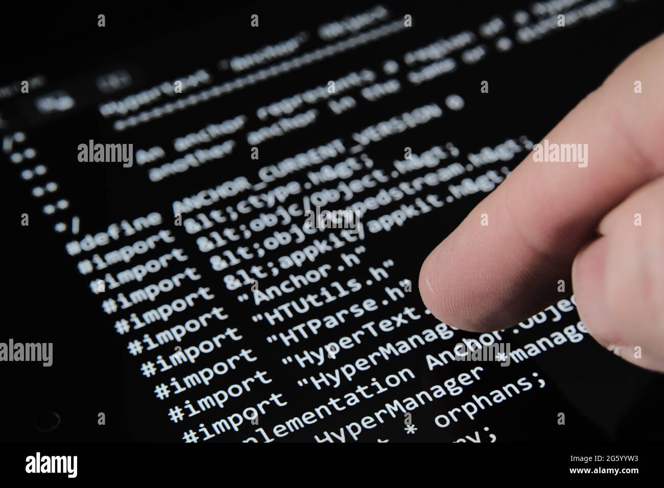 Verschwommener Finger berühren Tablet-Bildschirm mit dem ersten World Wide Web-Quellcode, der als NFT auf Auktion verkauft wurde. Selektiver Fokus. Konzept. Stafford, Stockfoto
