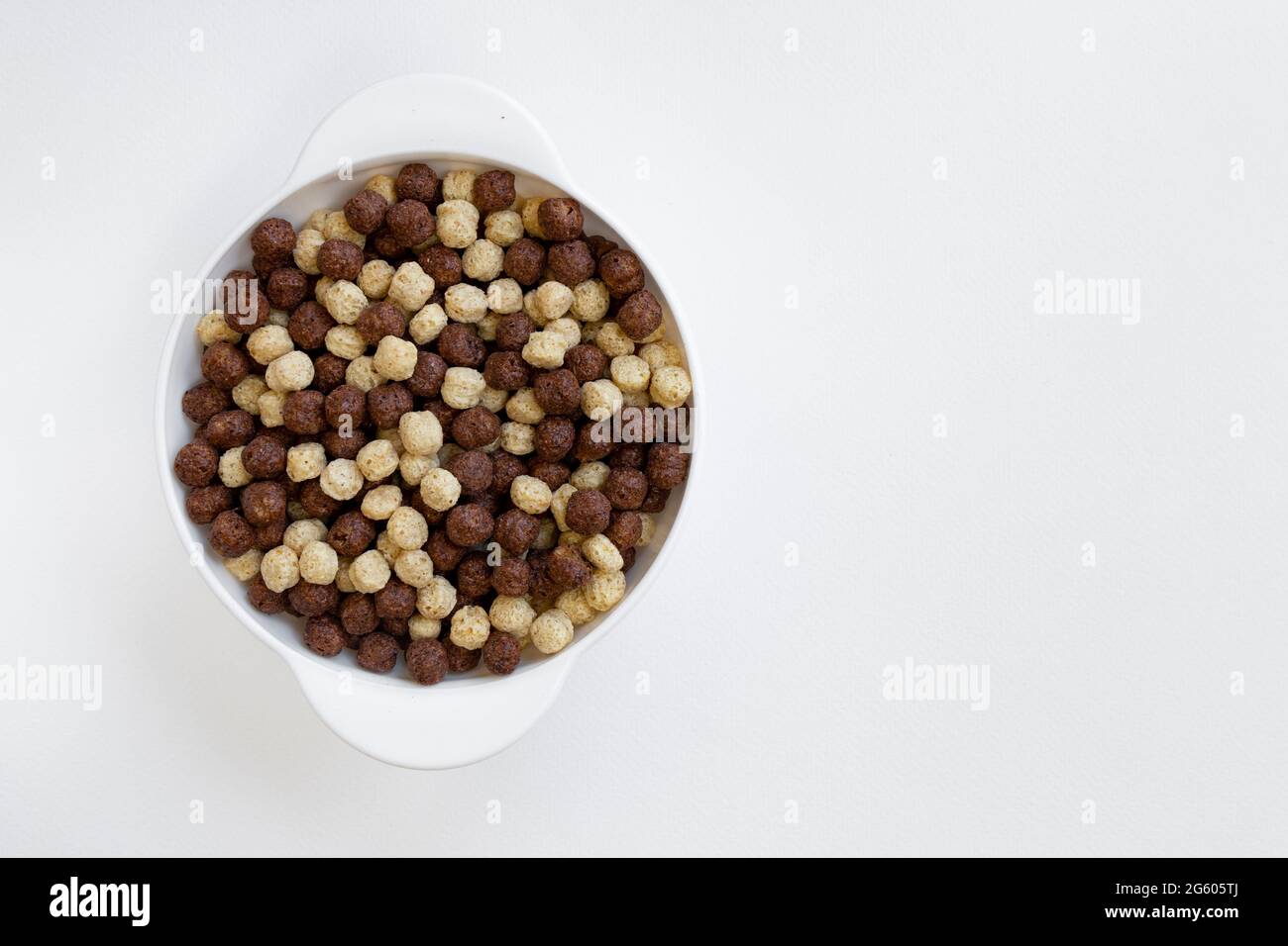 Schokolade und Vanille Müslischale isoliert auf weißem Hintergrund, Schokoladenkugeln, gesundes Frühstück Stockfoto