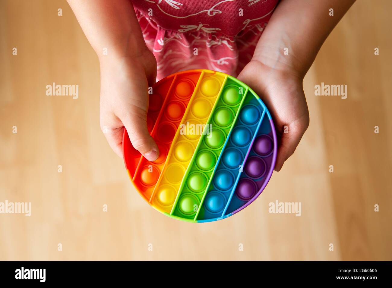 Nahaufnahme des kindlichen Spiels mit Regenbogenfarben beliebten Push-Pop-Blase sensorischen Fidget Spielzeug. Stockfoto