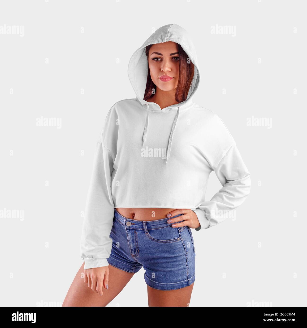 Vorlage leerer weißer Hoodie auf einem schlanken Modell in einer Kapuze, trendiges Crop Top für Designpräsentation, Vorderansicht. Nachbau eines weiblichen Sweatshirts auf ein Mädchen in Stockfoto