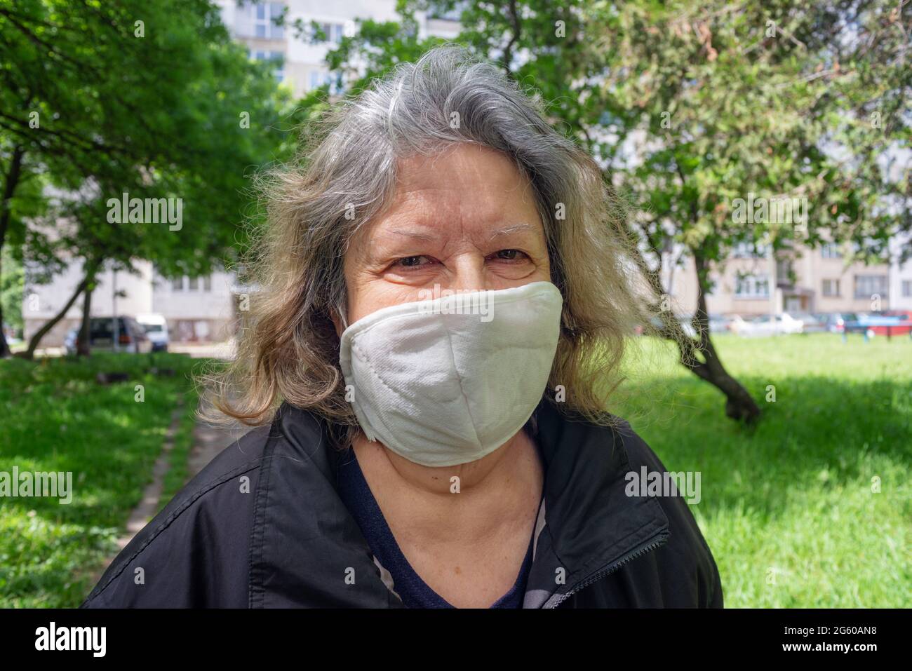 Ältere Frau Nahaufnahme Porträt im Freien mit schützender Coronavirus-Maske Stockfoto
