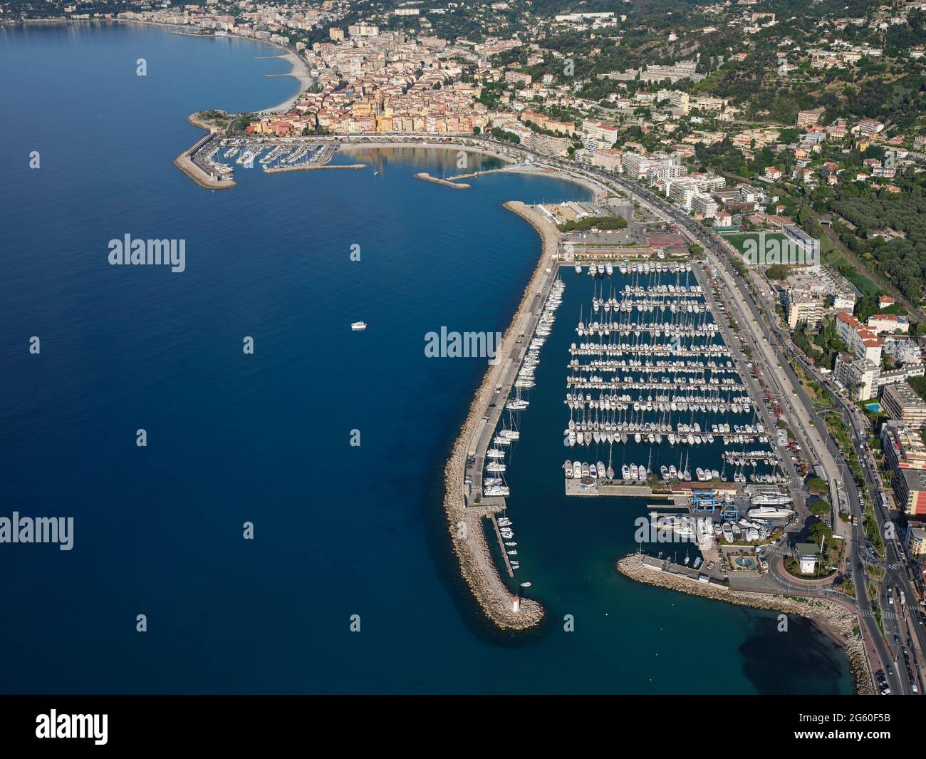 LUFTAUFNAHME. Marina von Menton Garavan mit der malerischen Altstadt von Menton in der Ferne. Französische Riviera, Alpes-Maritimes, Frankreich. Stockfoto