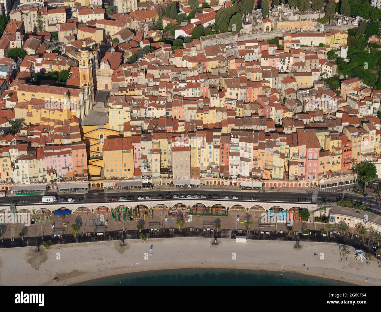 LUFTAUFNAHME. Altstadt mit bunten mehrstöckigen Häusern, die einen steilen Hügel hinunter zur Strandstraße führen. Menton, Französische Riviera, Frankreich. Stockfoto