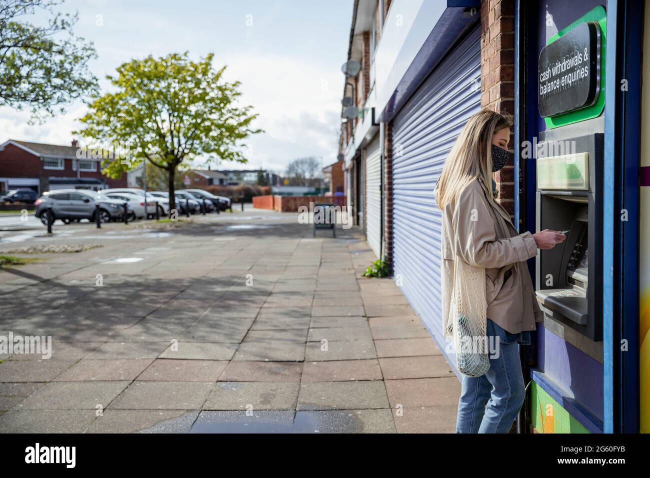 Eine Seitenansicht mit großem Kopierbereich einer kaukasischen Frau mit mittlerem Erwachsenen, die an einem Geldautomaten auf einer Stadtstraße eine Debitkarte verwendet, und sie trägt legeres Clothin Stockfoto