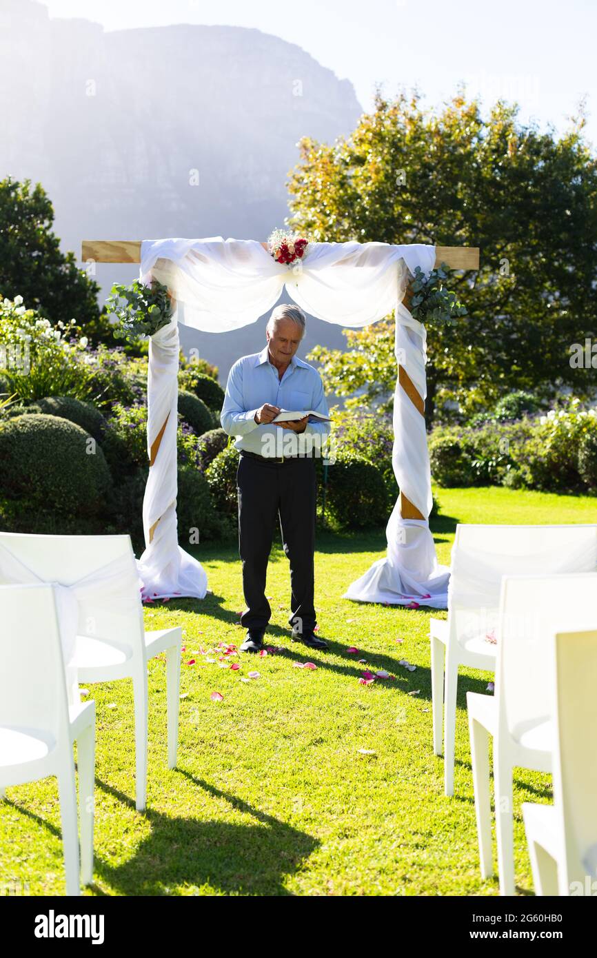 Leitender kaukasischer männlicher Hochzeitsoffizier bereitet sich vor der Hochzeitszeremonie vor Stockfoto