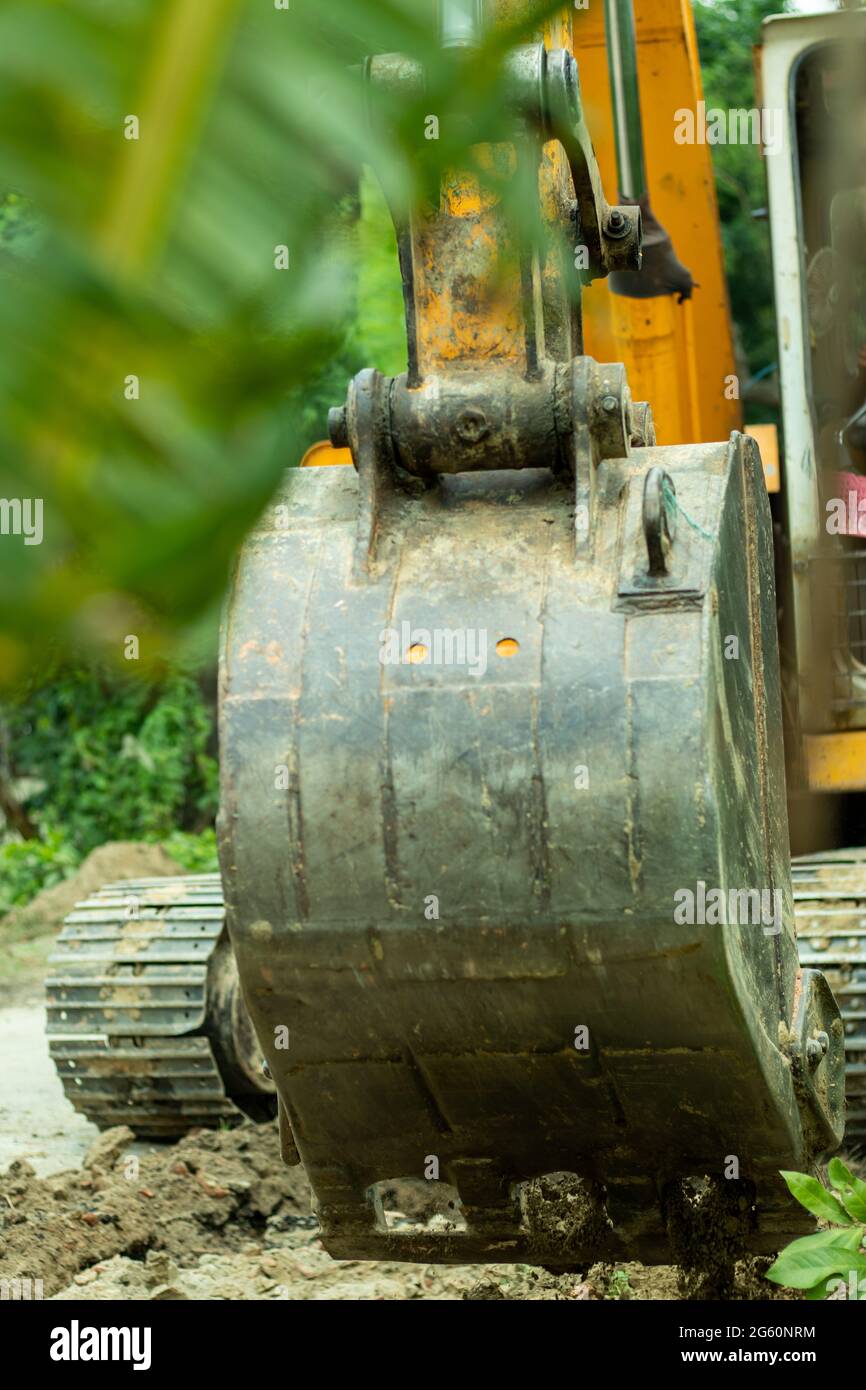 Der Bagger ist ein schweres Fahrzeug, das auf einer Straße für Ausgrabungen arbeitet Stockfoto