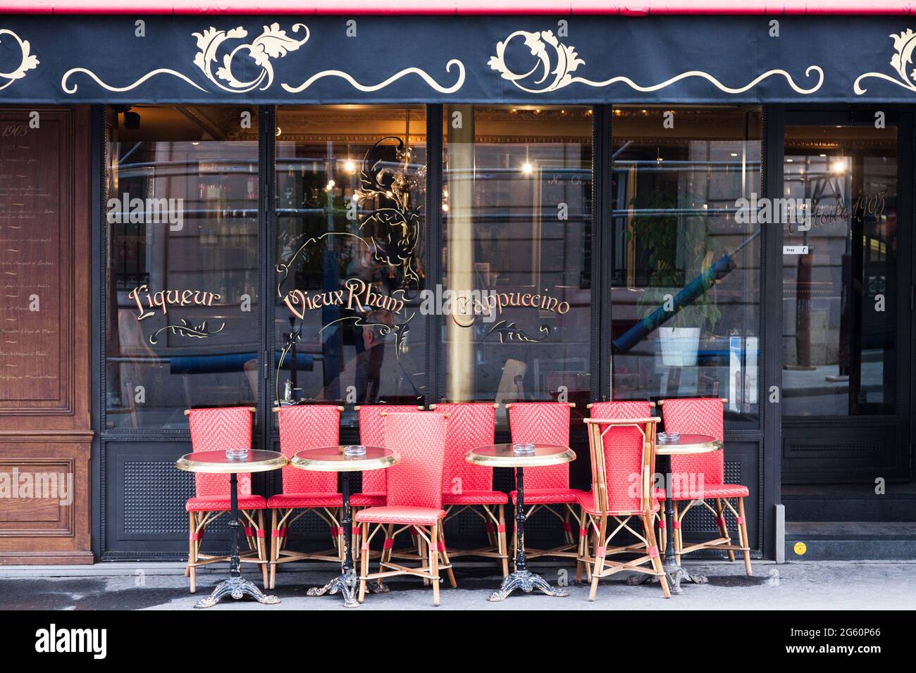 Terrasse eines Cafés in einer Straße in Paris, mit roten Sitzen. Stockfoto