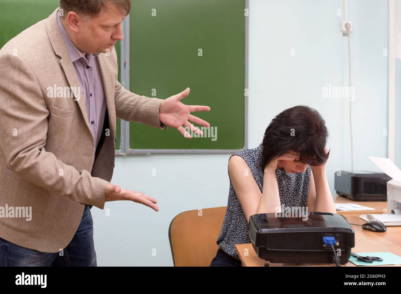 Der Regisseur schimpft den Lehrer für eine unerfüllte Aufgabe und wirft ihn mit einer Handbewegung aus dem Klassenzimmer. Stockfoto