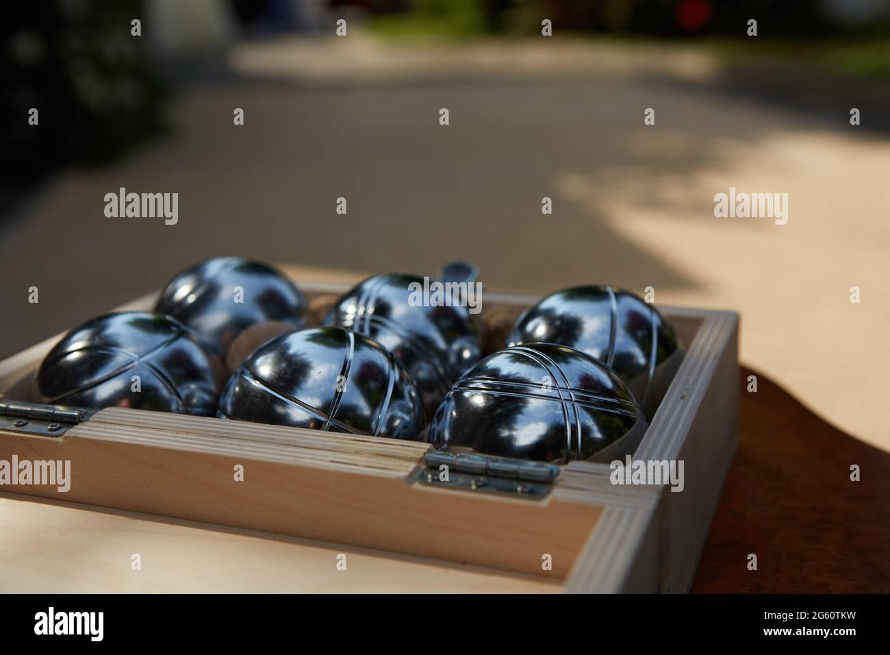 Sechs metallische Petanque-Kugeln in Holzkiste bereit zum Spielen Stockfoto