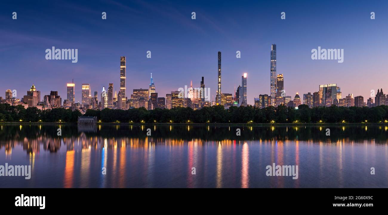 Skyline von New York City. Midtown Manhattan Wolkenkratzer vom Central Park Reservoir at Dusk. Blick am Abend auf die Milliardäre, die in superhohen Luxusgebäuden rudern Stockfoto