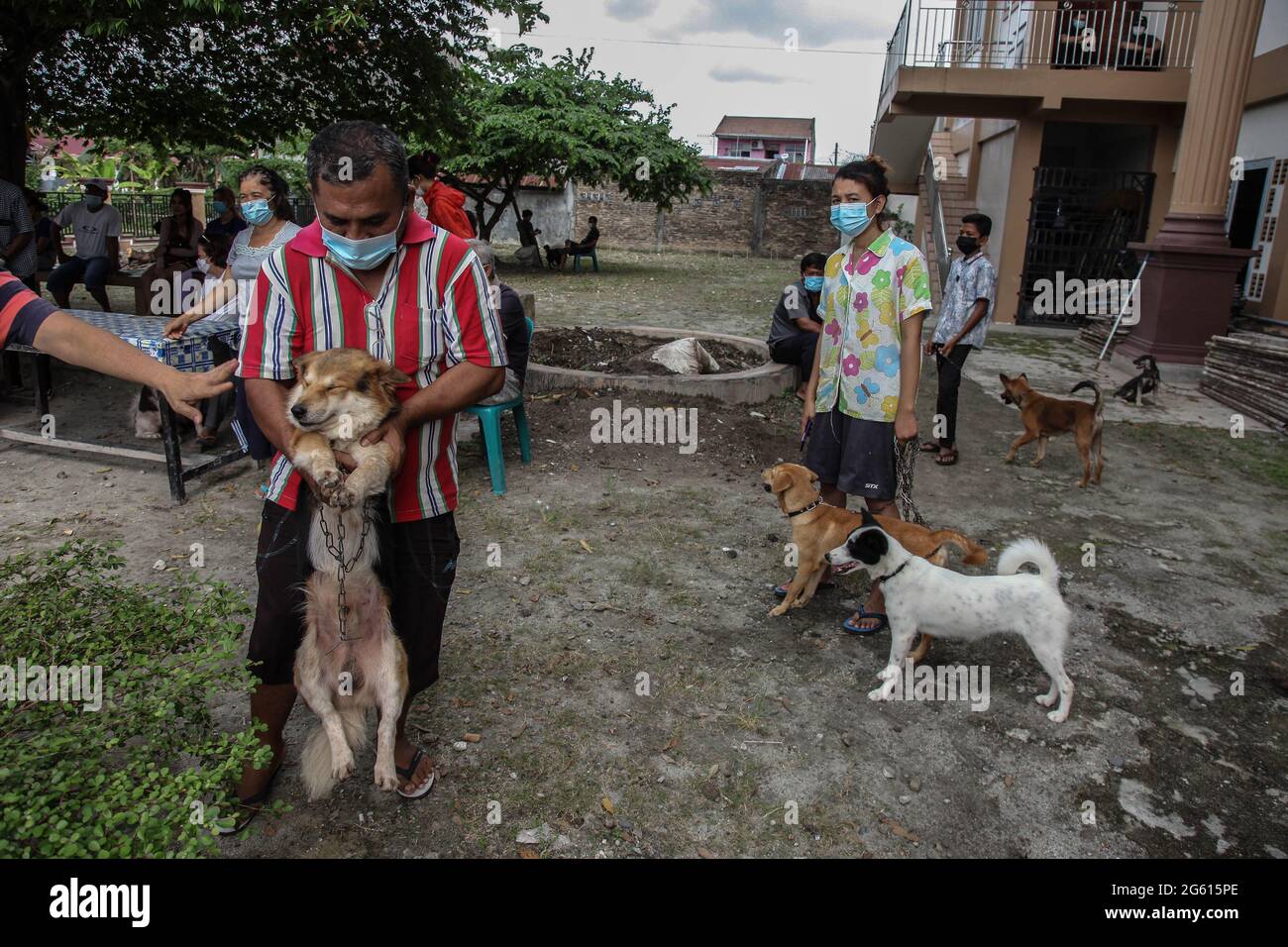 Medan, Nord-Sumatra, Indonesien. 28. Juni 2021. Die Menschen halten die Leine ihres Hundes an der Reihe, während indonesische Gesundheitshelfer am 28. Juni 2021 im indonesischen Medan, Indonesien, während einer Massenimpfung von Tieren mit Tollwutverdacht impfen. Die lokale Regierung des Gesundheitsdienstes Medan schlug die Beschaffung von 1,000 Fläschchen Tollwut-Impfstoff vor, um weitere Todesfälle zu vermeiden. Derzeit wurden mindestens 240 Heimtiere gegen Tollwut geimpft, nachdem festgestellt wurde, dass ein zehnjähriger Junge am Biss eines Nachbarhundes gestorben war, der am Sonntag, dem 13. Juni, Tollwut vermutet hatte. Bild: Ivan Damanik/Alamy Live N Stockfoto