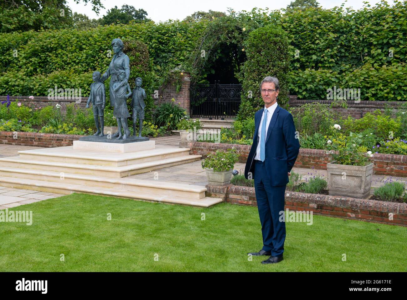 Der Bildhauer Ian Rank-Broadley mit seiner Statue von Diana, Prinzessin von Wales, im versunkenen Garten des Kensington Palace, London. Die Bronzestatue zeigt die Prinzessin, die von drei Kindern umgeben ist und die „Universalität und Generationenwirkung“ ihres Werks darstellt. Ihre kurzen, verkürzten Haare, ihr Kleidungsstil und ihr Porträt basieren auf der letzten Periode ihres Lebens. Unter der Statue ist ein Sockel mit ihrem Namen und dem Datum der Enthüllung eingraviert, und vor ist ein Pflasterstein mit einem Auszug, der vom Maß EINES man-Gedichts inspiriert wurde, eingraviert. Bilddatum: Donnerstag, 1. Juli 2021. Stockfoto