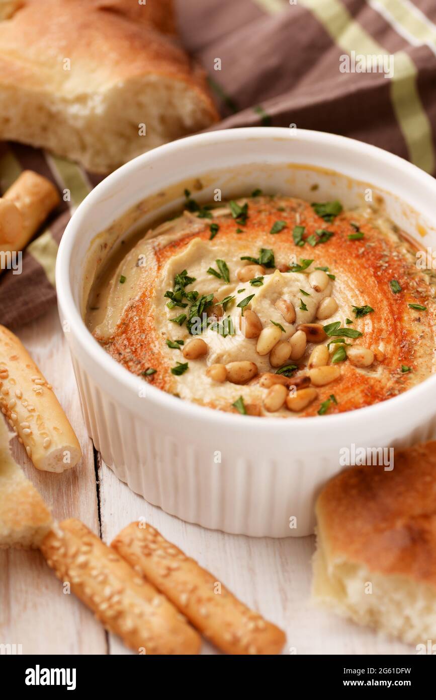 Nahaufnahme von Hummus mit Pinienkernen und frischem Brot Stockfoto