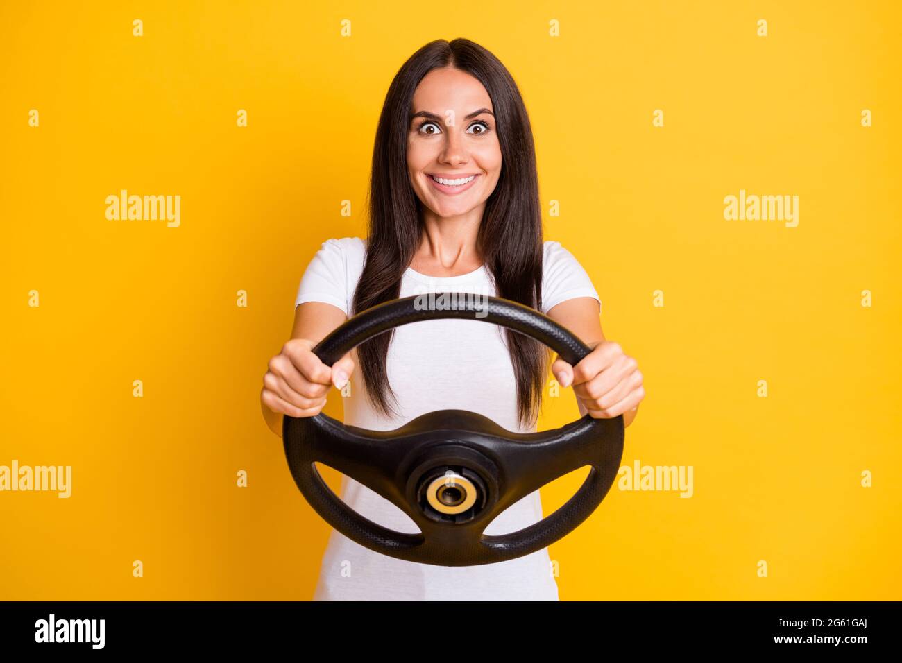 Portrait Foto verrückt Brünette halten Lenkrad üben Fahrer Lektion isoliert auf hellen gelben Hintergrund Stockfoto
