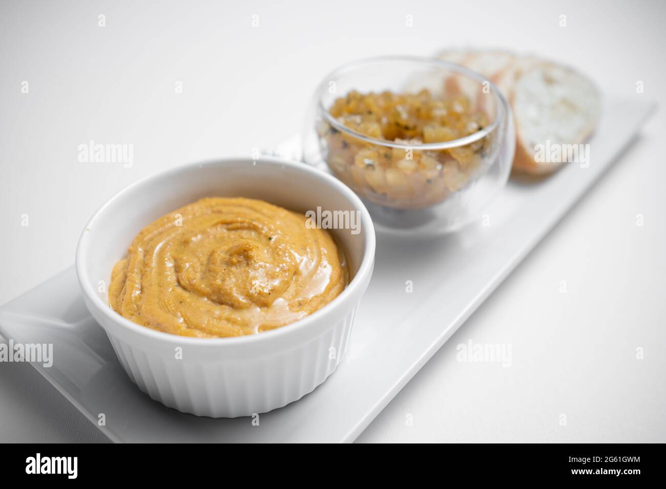 Nahaufnahme von Gänseleber-Pastete mit Apfelchutneys und Brot auf weißem Hintergrund Stockfoto