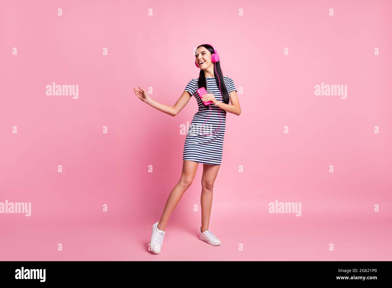 In voller Länge Körpergröße Ansicht der charmanten fröhlich mager Mädchen hören Lied tanzen isoliert auf rosa Pastellfarbe Hintergrund Stockfoto