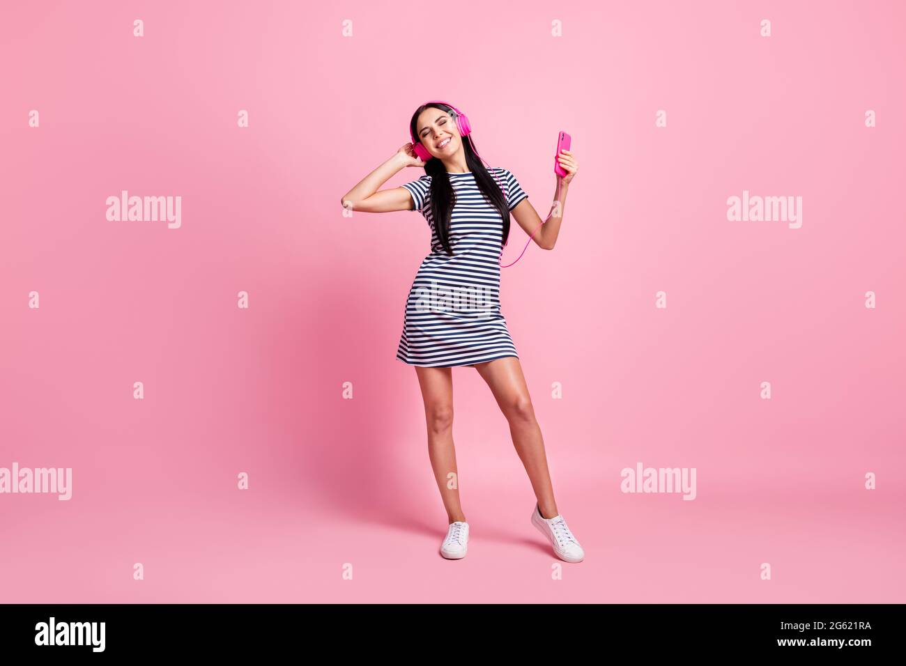 In voller Länge Körpergröße Ansicht der ziemlich fröhlich dünne Mädchen hören verschiedene Song Rock tanzen isoliert auf rosa Pastellfarbe Hintergrund Stockfoto