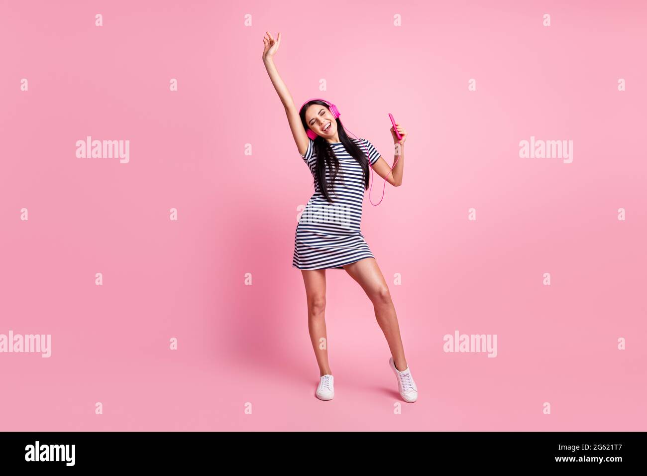 In voller Länge Körpergröße Ansicht der charmanten fröhlich dünne Mädchen hören Song Rock tanzen Spaß isoliert auf rosa Pastellfarbe Hintergrund Stockfoto