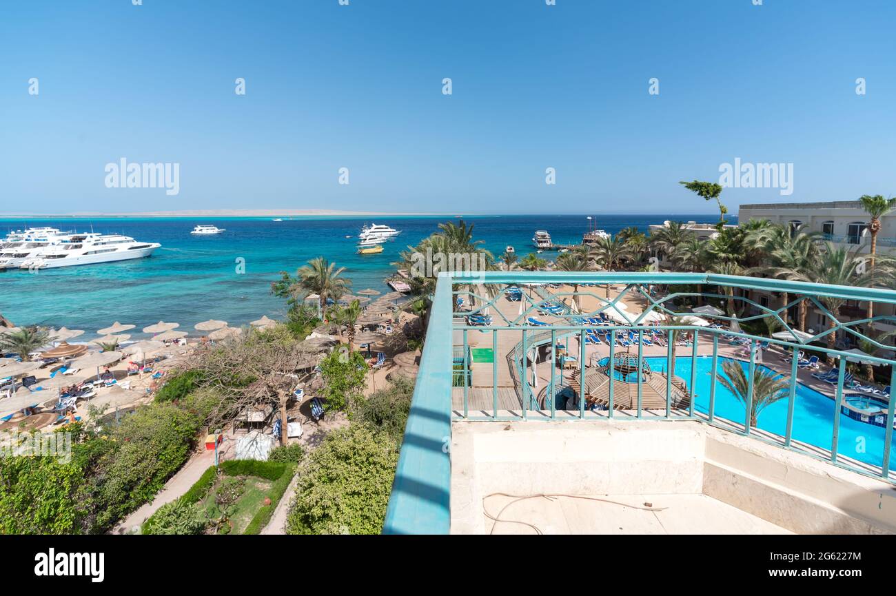 Panoramablick auf das Hotel mit einem Pool ohne Menschen und das Rote Meer mit Schiffen Boote in Ägypten Stockfoto
