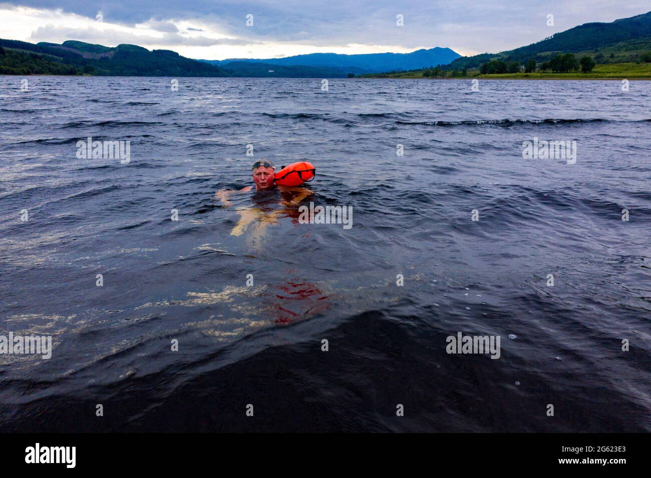 Loch Venachar, Loch Lomonnd und Trossachs National Park, Schottland, Großbritannien. Juli 2021. BILD: Drone Luftaufnahme von oben auf einen wilden Schwimmer mit der Schwärze des torfreichen Wassers von Loch Venachar. Wildes Schwimmen wird immer beliebter mit mehr Menschen, die während des Lockdowns ins Wasser gehen, und es gibt viele gesundheitliche Vorteile zusammen mit der Förderung der psychischen Gesundheit der Menschen zu. Quelle: Colin Fisher/Alamy Live News Stockfoto