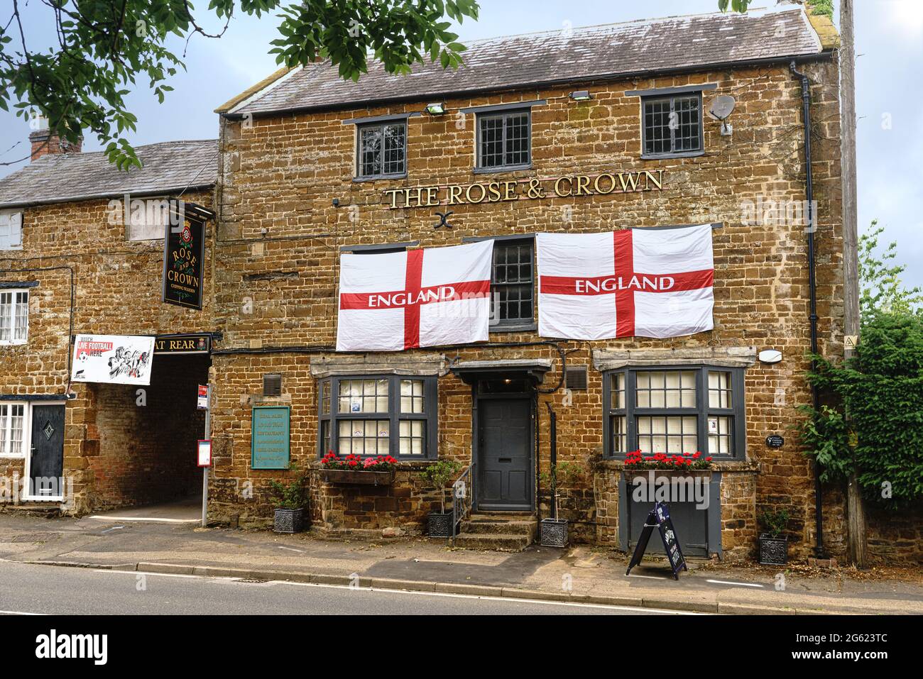 Zwei englische Flaggen hängen im Pub Rose and Crown in Chipping Warden, Northamptonshire, zur Unterstützung der englischen Fußballmannschaft. Stockfoto