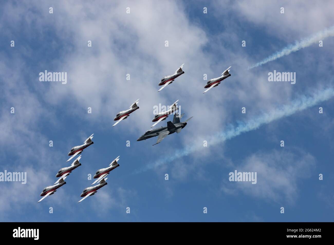 Ottawa, Ontario, Kanada - 1. Juli 2021: Die Snowbirds der kanadischen Streitkräfte fliegen in Formation mit einem CF-18-Demojet in einer Canada Day Demonstration. Stockfoto