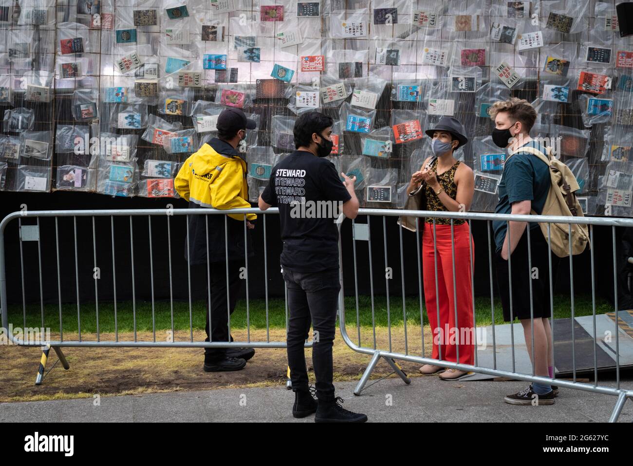 Manchester, Großbritannien. Juli 2021. MIF kehrt in die Stadt zurück. Besucher stehen Schlange, um die Installation Big Ben Lying Down zu sehen, die bei der artistÊMarta Minuj'no liegt Die 42 m lange Nachbildung von Big Ben ist in 20,000 Exemplaren von Büchern überdeckt, die die britische Politik geprägt haben und eine freudige Einladung für die Menschen sind, sich ihre nationalen Symbole neu zu denken und sich um Demokratie und Gleichheit zu vereinen. Das MIF ist ein von Künstlern angeführtes Festival, das neue Werke aus verschiedenen darstellenden Künsten, bildender Kunst und Populärkultur präsentiert. Kredit: Andy Barton/Alamy Live Nachrichten Stockfoto
