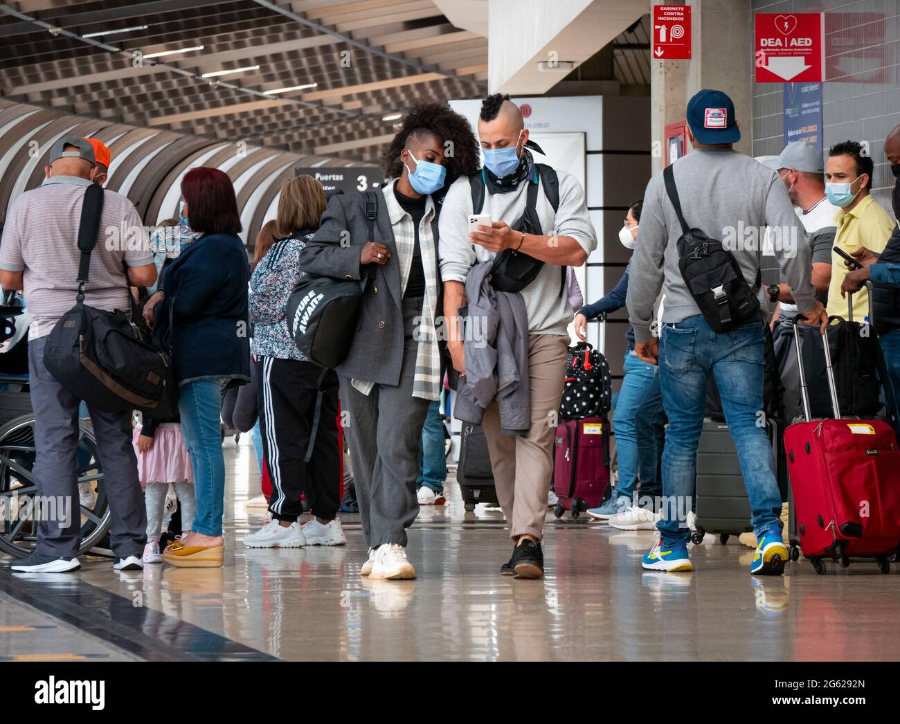 Medellin, Antioquia, Kolumbien - Mai 17 2021: Lateinisches Paar mit Maske geht mit ihren Taschen am Jose Maria Cordova Airport Terminal spazieren Stockfoto