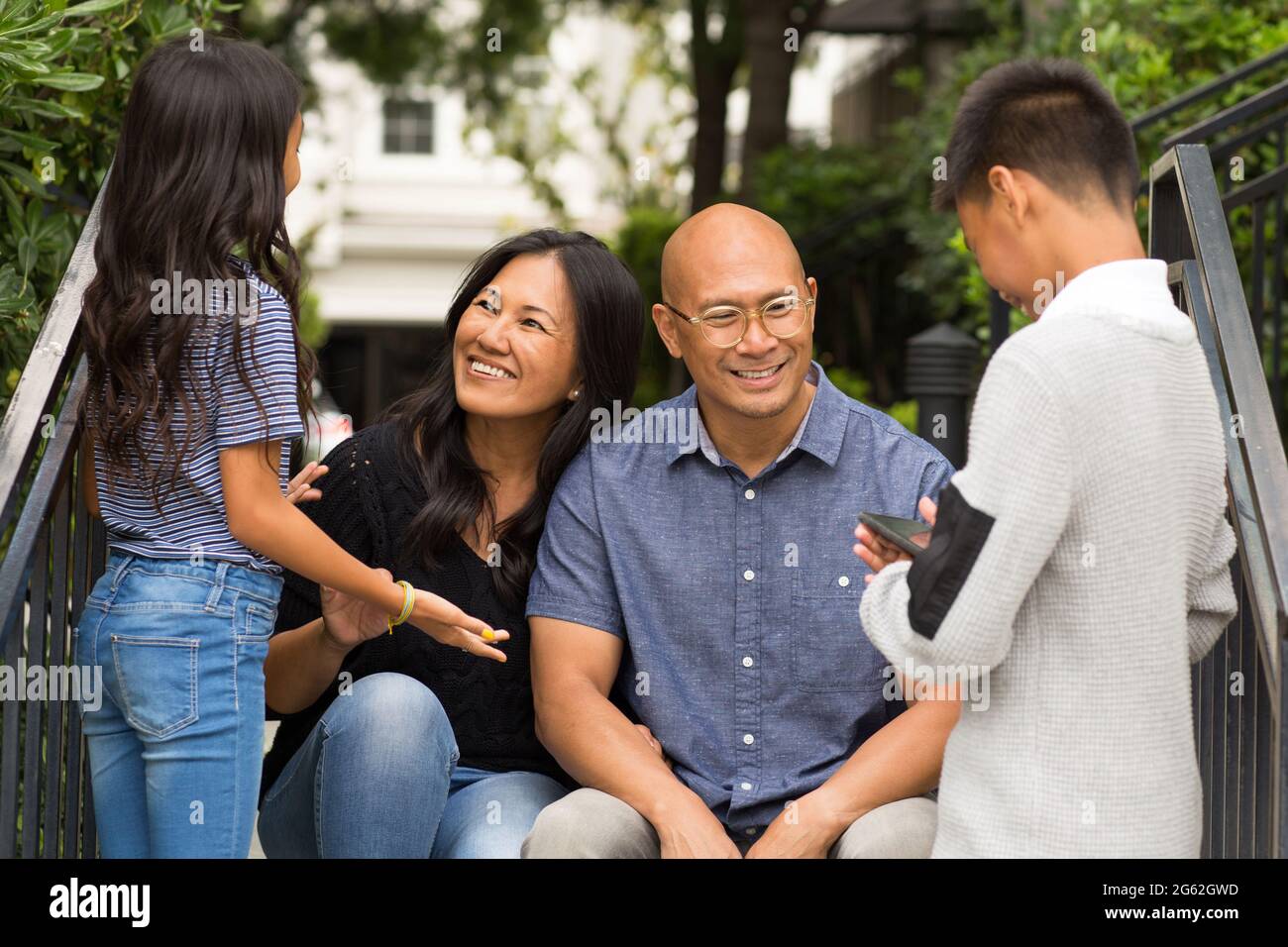 Porträt einer asiatischen Familie, die draußen lacht und spricht. Stockfoto