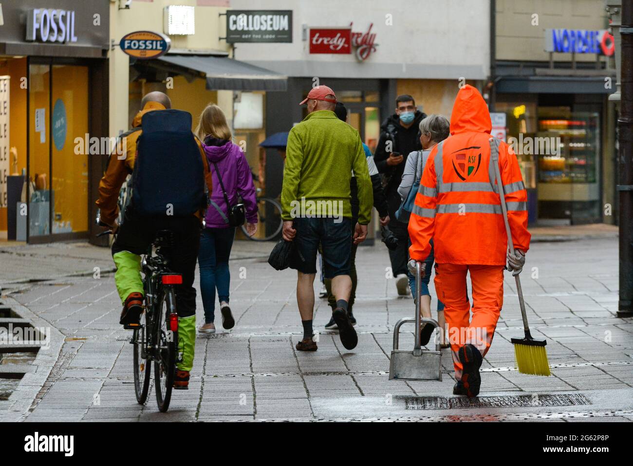 Freiburg im Breisgau, 29. Juni 2021: Nach einem Gewitter füllt sich die Rathausgasse wieder mit Passanten. Ein Mitarbeiter des öffentlichen Versorgungsunternehmens zieht Aufmerksamkeit auf sich. Stockfoto