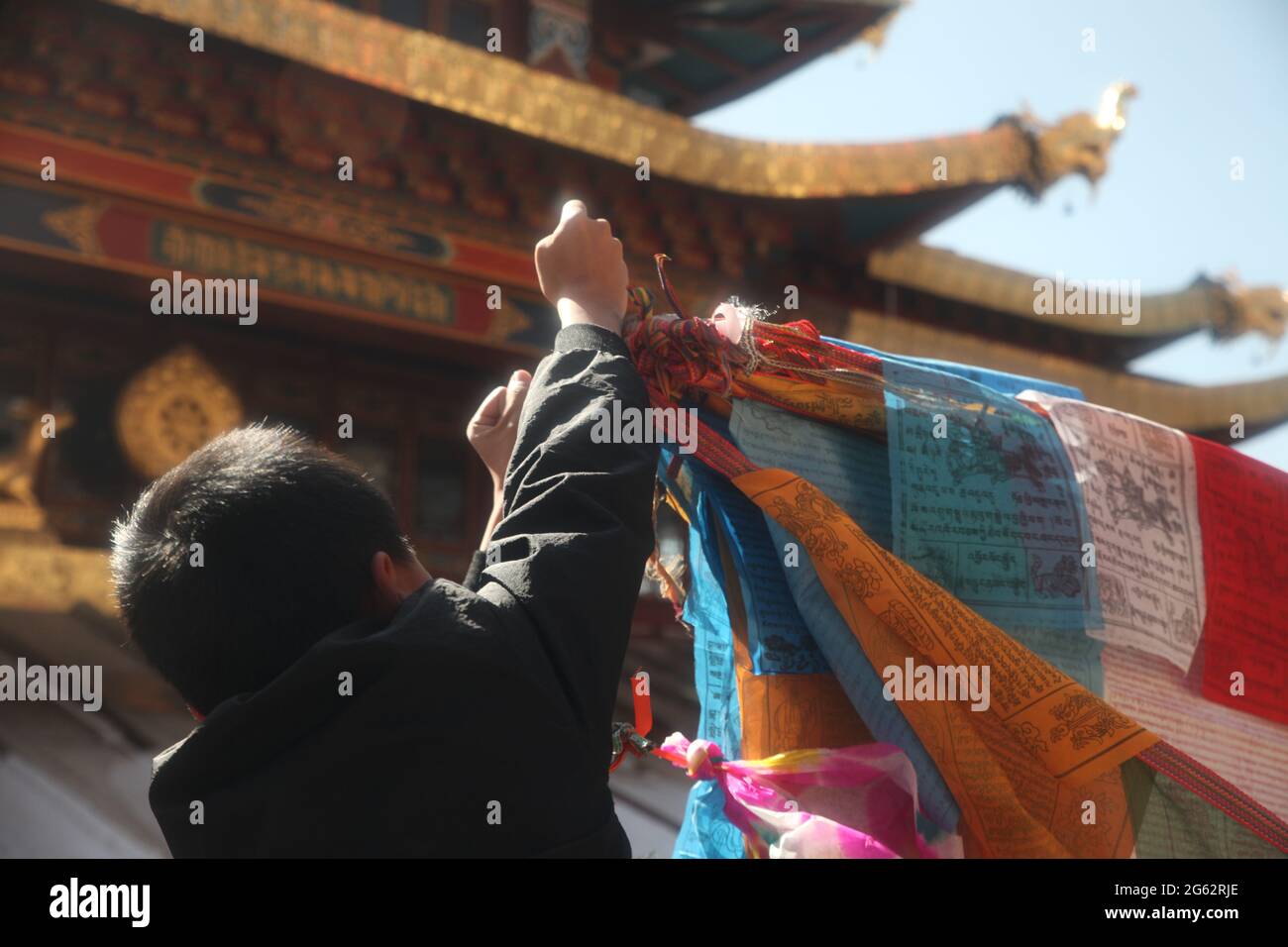 Ein kleiner Junge bindet während des Frühlingsfestes in Yunann, China, ein preyer-Banner an Shangri-La, 2018, und bringt Glück für das folgende Jahr. Stockfoto