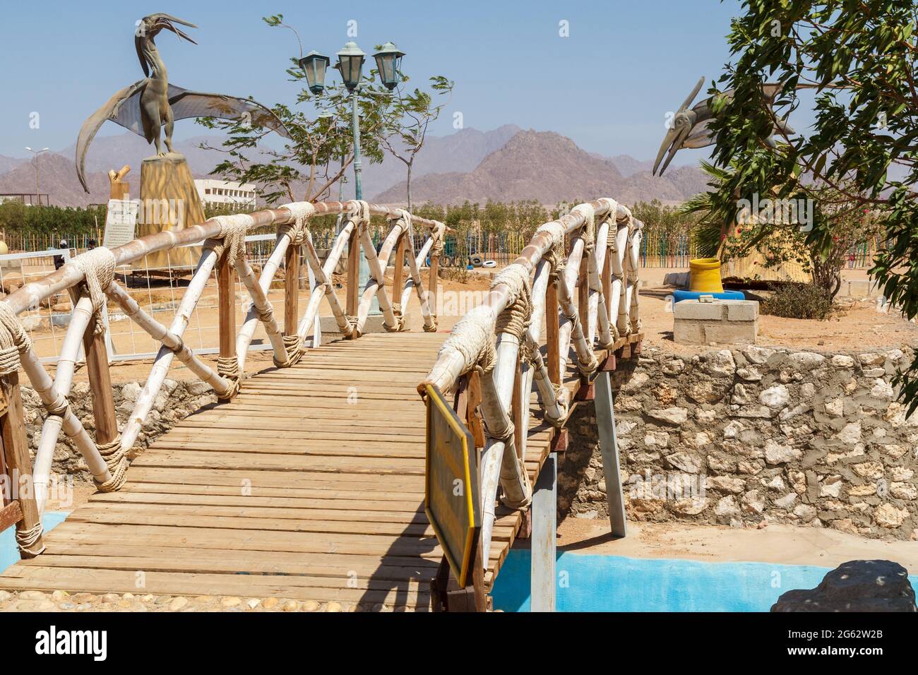 SHARM EL SHEIKH, ÄGYPTEN - 3. JUNI 2021: Brücke und Figuren von Dinosauriern in einem Park der Stadt Sharm el Sheikh in Ägypten. Stockfoto