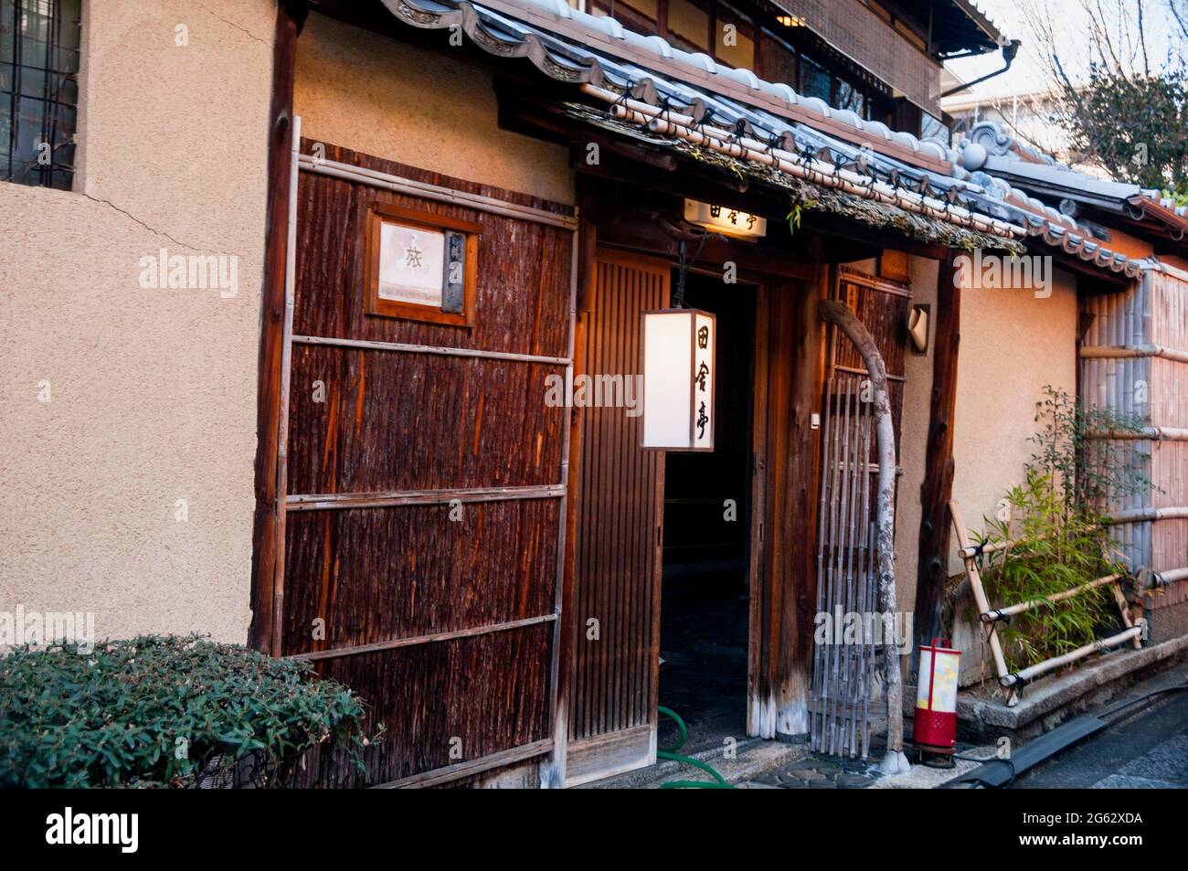 Verschiebbare Bambusgitter und Lehmbachziegel eines Machiya-Hauses aus Holz in Kyoto, Japan. Stockfoto